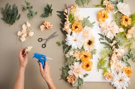 glue gun attaching faux flower to board