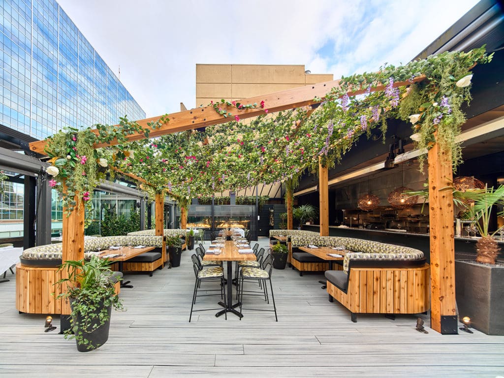 Outdoor synthetic plants used in commercial spaces like hotel terraces and retail entrances.