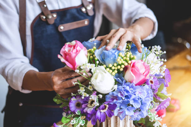using a soft brush to clean silk flowers on a living room coffee table