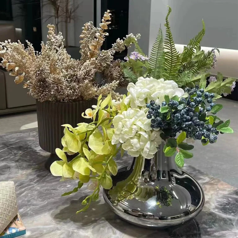 Mixed artificial hydrangea and foliage arrangement in a silver vase