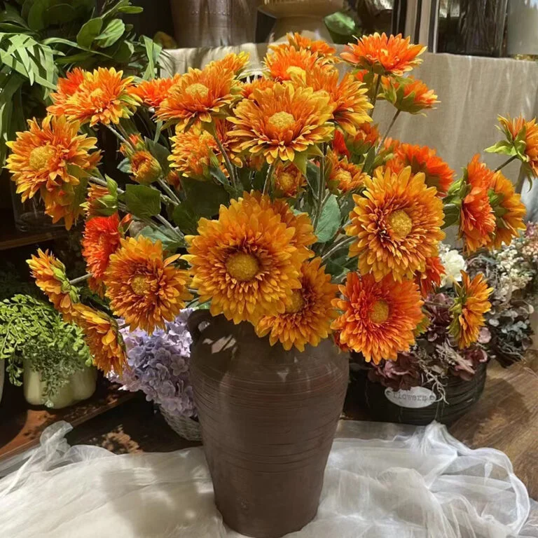 Orange artificial chrysanthemum bouquet in a brown vase