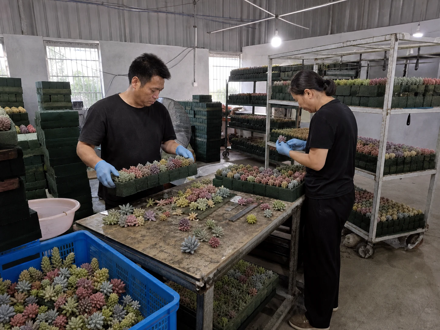 Workers inspecting and sorting multicolor artificial succulent heads for quality control