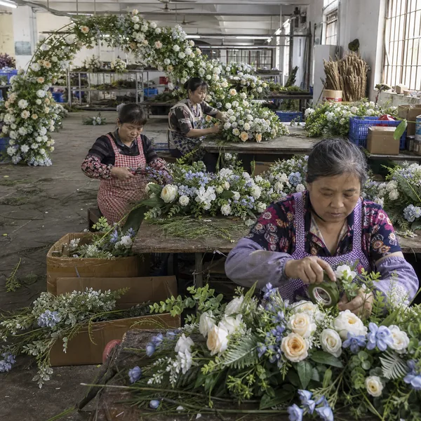 Chinese workers producing bulk artificial wedding flower arches and centerpieces