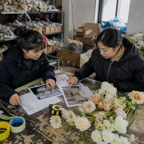 Chinese artificial wedding flower factory team reviewing a wholesale project brief