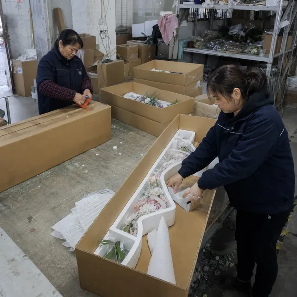 Chinese factory team packing artificial wedding flower arrangements for export