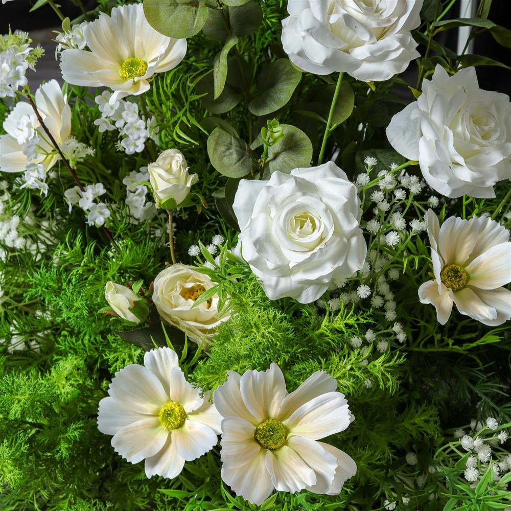 Close-up of white roses, cosmos and fern in an artificial arch flower piece