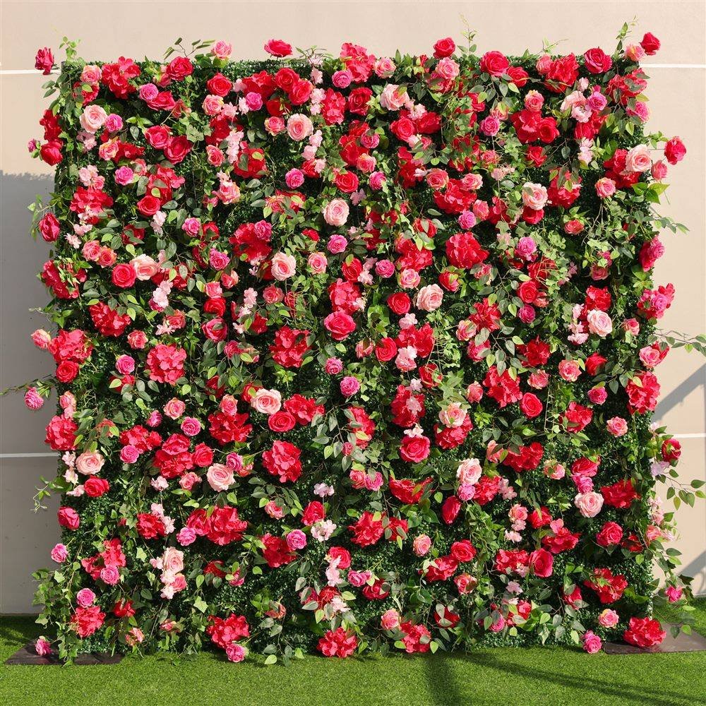 Red and pink rose artificial flower wall on green foliage