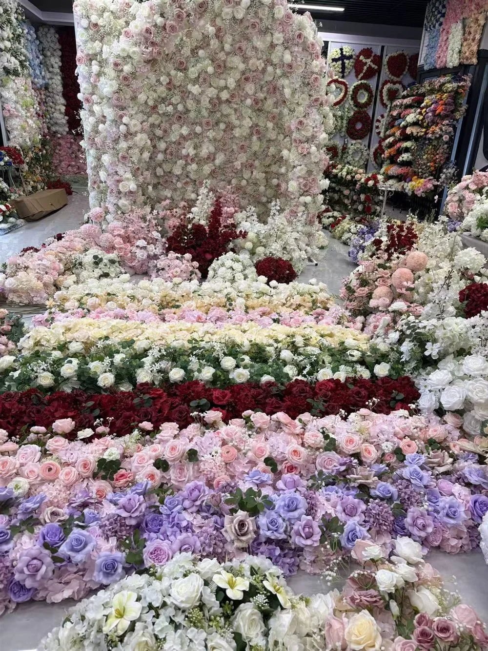 Arched artificial flower wall and rows of wedding table flower runners in the Botanicblossoms showroom